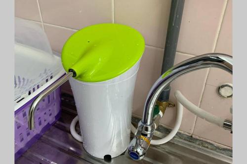 a bucket with a green lid in a sink at STAY N REST SWEET HOME Duyung 207 in Seremban