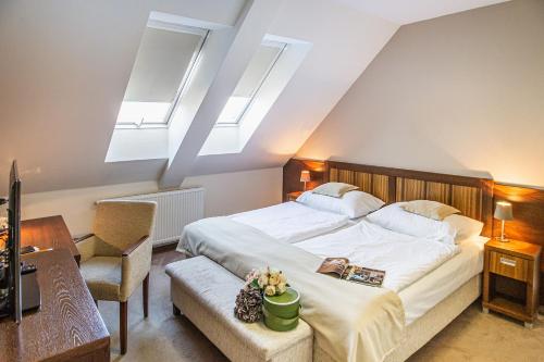 Schlafzimmer mit einem großen weißen Bett und Oberlichtern in der Unterkunft Hotel Academic in Zvolen