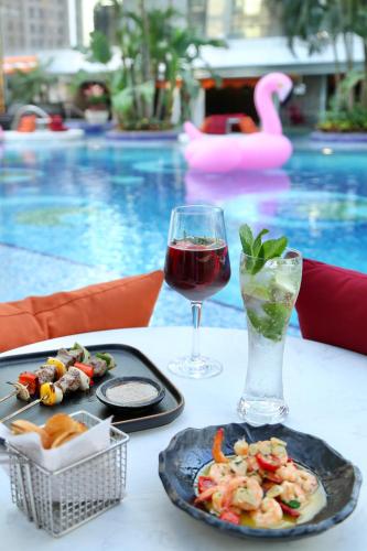 a table with a plate of food and a glass of wine at Jumeirah Guangzhou - Complimentary Shuttle Bus to Canton Fair Complex in Guangzhou