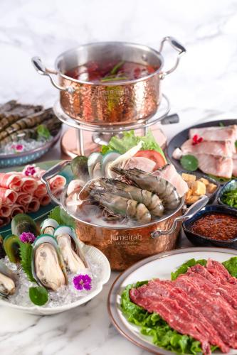a table topped with plates of seafood and meat at Jumeirah Guangzhou - Complimentary Shuttle Bus to Canton Fair Complex in Guangzhou