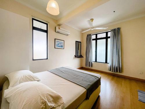 a bedroom with a bed and two windows at Alyssa Homestay Putrajaya in Putrajaya