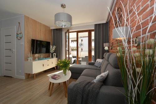 Apartment Premium Wood Baltic Park - 58m2, 3 pokoje في ستيغنا: غرفة معيشة مع أريكة وطاولة