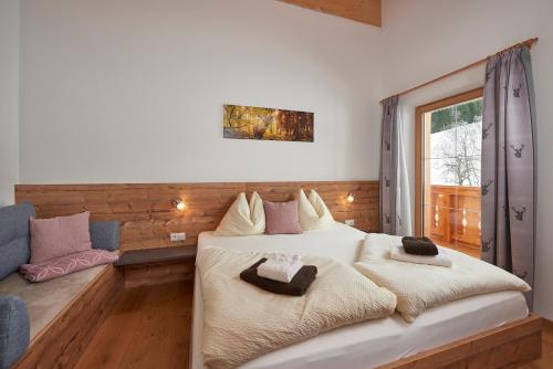 - une chambre avec un grand lit et une fenêtre dans l'établissement Ferienhaus Rohrmoos Maria Alm, à Maria Alm