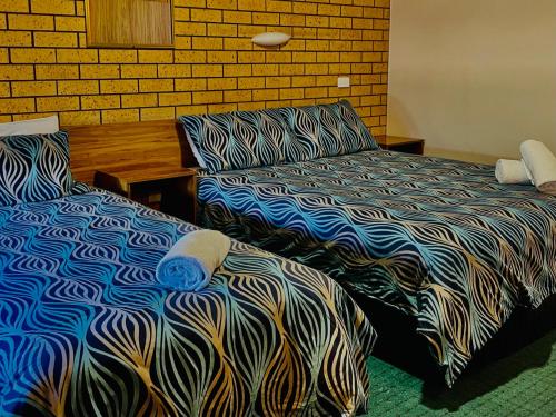 two beds sitting next to each other in a room at Lake Mulwala Hotel in Mulwala