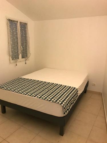 une petite chambre avec un lit dans une pièce dans l'établissement L'échoppe Rochelaise, à La Rochelle