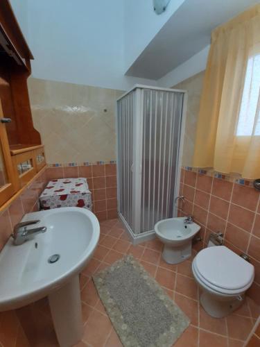 a bathroom with a white sink and a toilet at La casetta di pietra in Trapani