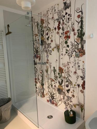 a shower with a floral wallpaper on the wall at Manciuno in Trento