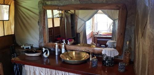 a bathroom counter with a sink and a mirror at Mara Siria Tented Camp & Cottages in Aitong