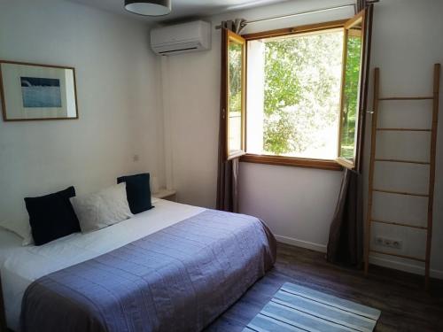 ein Schlafzimmer mit einem Bett und einem Fenster in der Unterkunft Les jardins de Foata in Barbaggio