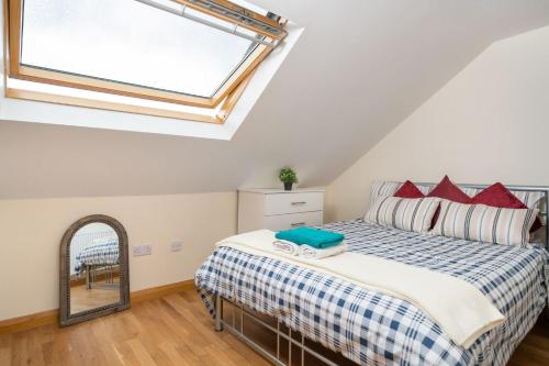 a bedroom with a bed with a window and a mirror at S6 Ensuite Loft Studio Space (Sandycroft Guest House) in London