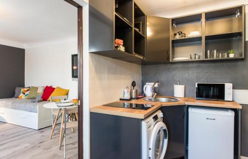 a kitchen and living room with a washer and dryer at Old town 5 min. 4 can stay! Free parking. Self check in/out. in Rīga