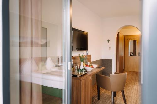 um quarto de hotel com uma secretária e uma cadeira em Hotel Aichingerwirt em Mondsee