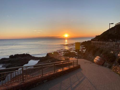 a sunset over the ocean with the sun setting at Buggerru a Mare Residence in Buggerru