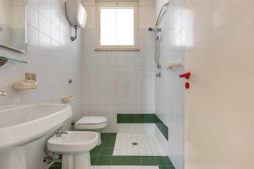 La salle de bains blanche est pourvue de toilettes et d'un lavabo. dans l'établissement Villa Vival by BarbarHouse, à Campomarino