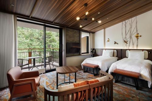 a bedroom with two beds and a balcony at Karuizawa Prince Hotel West in Karuizawa