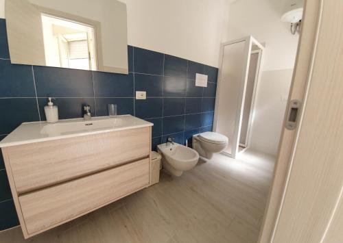 łazienka z umywalką, toaletą i lustrem w obiekcie Casa Orfeo w mieście Marina di Ragusa