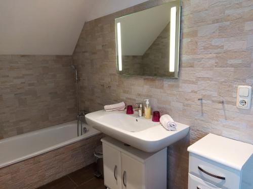 a bathroom with a sink and a mirror and a tub at K3 Ferienhaus in Strobl