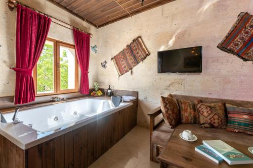 a large bath tub in a room with a couch at Lord of Cappadocia Hotel in Goreme