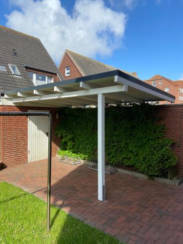 a pavilion in front of a brick building at STRANDHUUS Norddeich in Norddeich