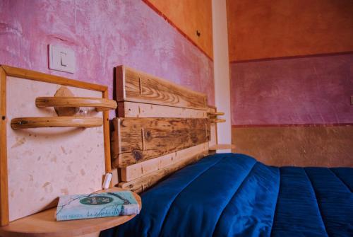 a bedroom with a bed with a wooden head board at B&B Terra e Paglia in SantʼAnna