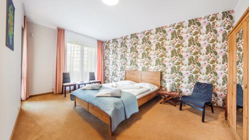 a bedroom with a bed and a floral wallpaper at Olympic Park I, Sun & Snow in Kołobrzeg