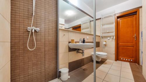 a bathroom with a shower and a sink and a toilet at Olympic Park I, Sun & Snow in Kołobrzeg