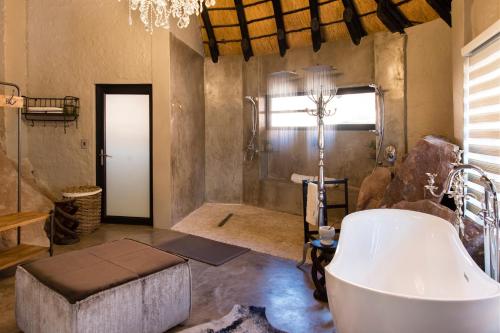 a bathroom with a large tub and a window at Twyfelfontein Country Lodge in Twyfelfontein