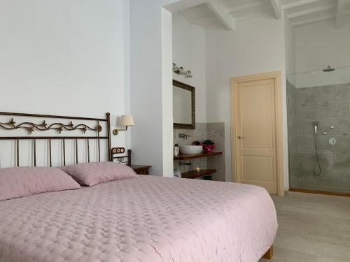 a bedroom with a pink bed and a shower at Seranova Luxury Hotel - Adults Only in Ciutadella