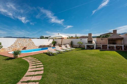 a backyard with a swimming pool and lounge chairs at Villa Gle in Quartu SantʼElena