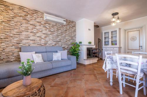 a living room with a couch and a brick wall at Villa Gle in Quartu SantʼElena