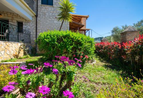 a garden of flowers in front of a house at Ammos Zante Villas in Vasilikos