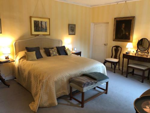 a bedroom with a large bed and a table and chairs at Marston Hall in Grantham