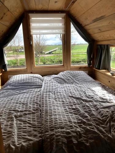 a large bed in a room with a window at De Greide- Camping Buorren1 in Warstiens