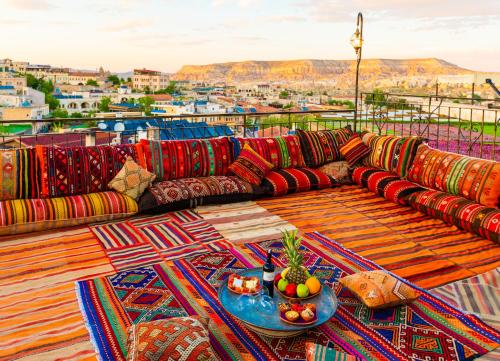 a couch on a balcony with a table with fruit at Lord of Cappadocia Hotel in Göreme
