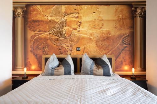 ein Schlafzimmer mit einem Bett und einem Gemälde an der Wand in der Unterkunft Villa Santa Maria in Vrbnik