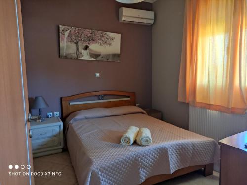 sypialnia z łóżkiem i dwoma ręcznikami na nim w obiekcie Eliza Apartment w Lixoúrion