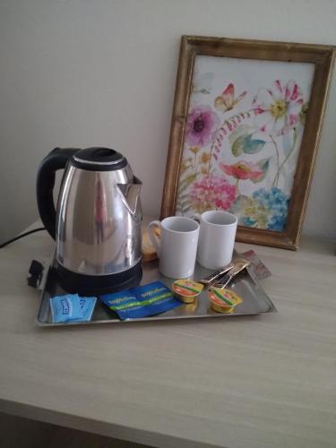 een dienblad met een koffiepot en kopjes op een tafel bij M. BINI B&B in Bologna