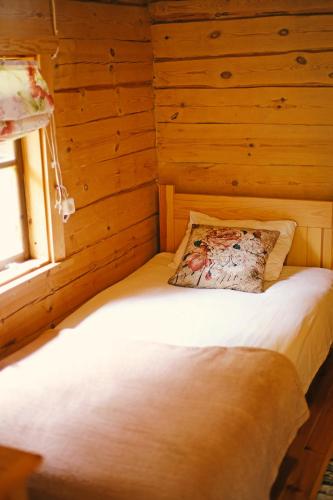 a bed in a wooden room with a window at Niidupuu Camping in Mändjala