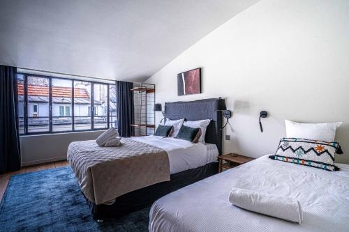 une chambre d'hôtel avec deux lits et une fenêtre dans l'établissement 135 - Urban Five Star Apartment in Center of Paris, à Paris