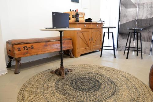 a room with a table with a laptop on top of a rug at The Old Bakery in Cagliari