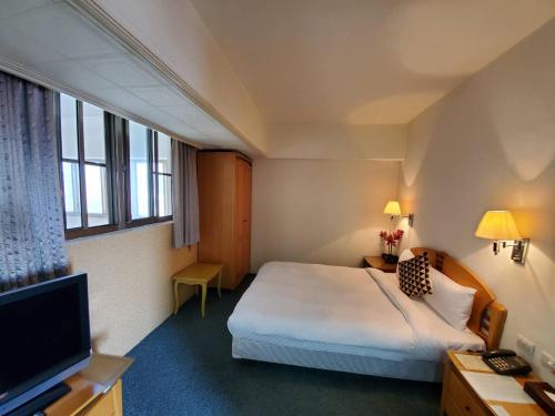 מיטה או מיטות בחדר ב-Berkeley Business Hotel Zhongzheng
