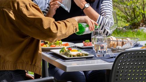 a group of people sitting at a table eating food at Hotel Il Castagno in Mugena