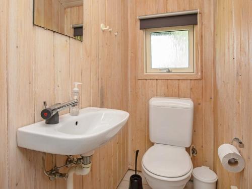 a bathroom with a white sink and a toilet at Holiday home Idestrup in Marielyst