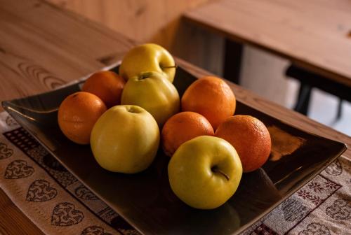 a plate of fruit on a wooden table at Chalet Auszeit in Lermoos