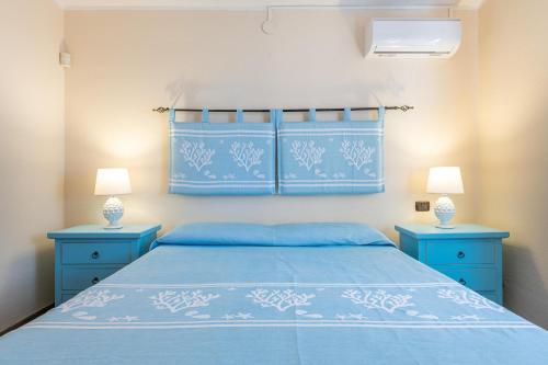 a bedroom with a blue bed and two blue night stands at Villa Gle Apt 1 in Quartu SantʼElena