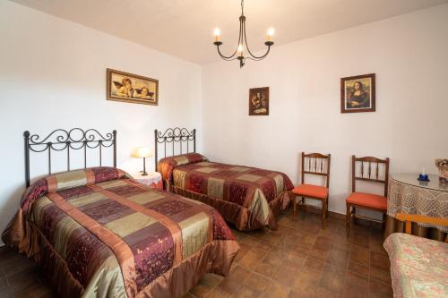 Zimmer mit 2 Betten, einem Tisch und Stühlen in der Unterkunft Cortijo La Huerta in Torrox