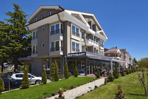 a large building with cars parked in front of it at Vila Europa in Struga