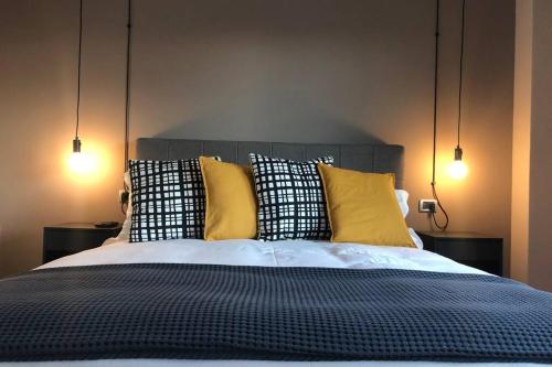 a bedroom with a bed with yellow and black pillows at laus via sparano - lux & design mini in Bari