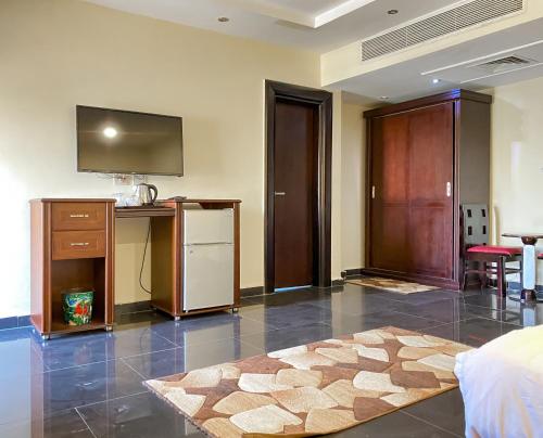 a room with a bed and a television and a table at Best View Pyramids Hotel in Cairo
