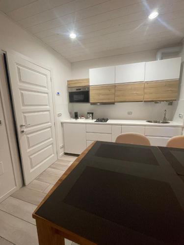 a kitchen with white cabinets and a table and chairs at Casa Morena Locazione Turistica in Malesco